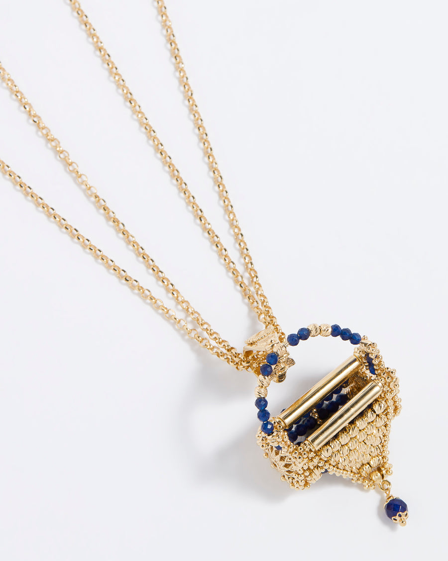 Product shot of a tiny little gold jewel woven bag hung from a double folded necklace.