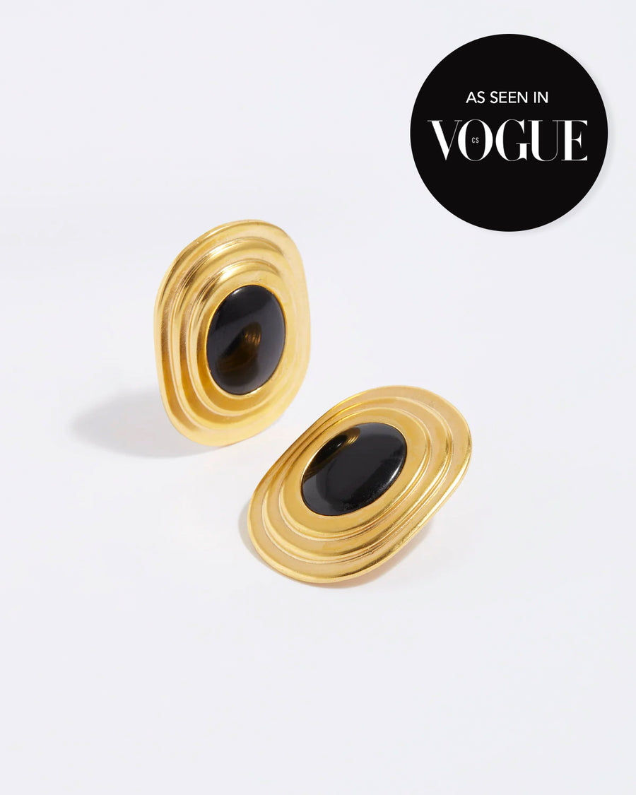 product shot of oversized gold plated silver stud earrings with oval black onyx centre