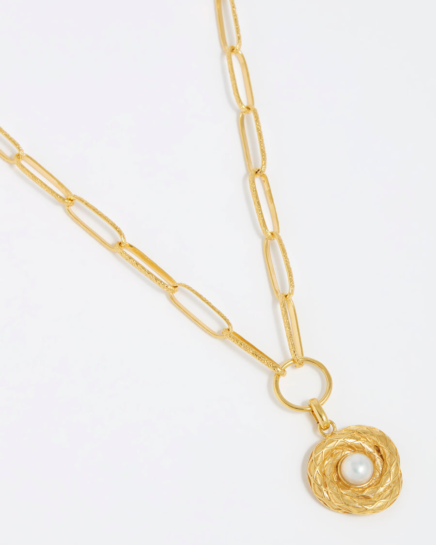 Product shot of gold textured charm with pear centre hung from a gold chunky charm chain on white background