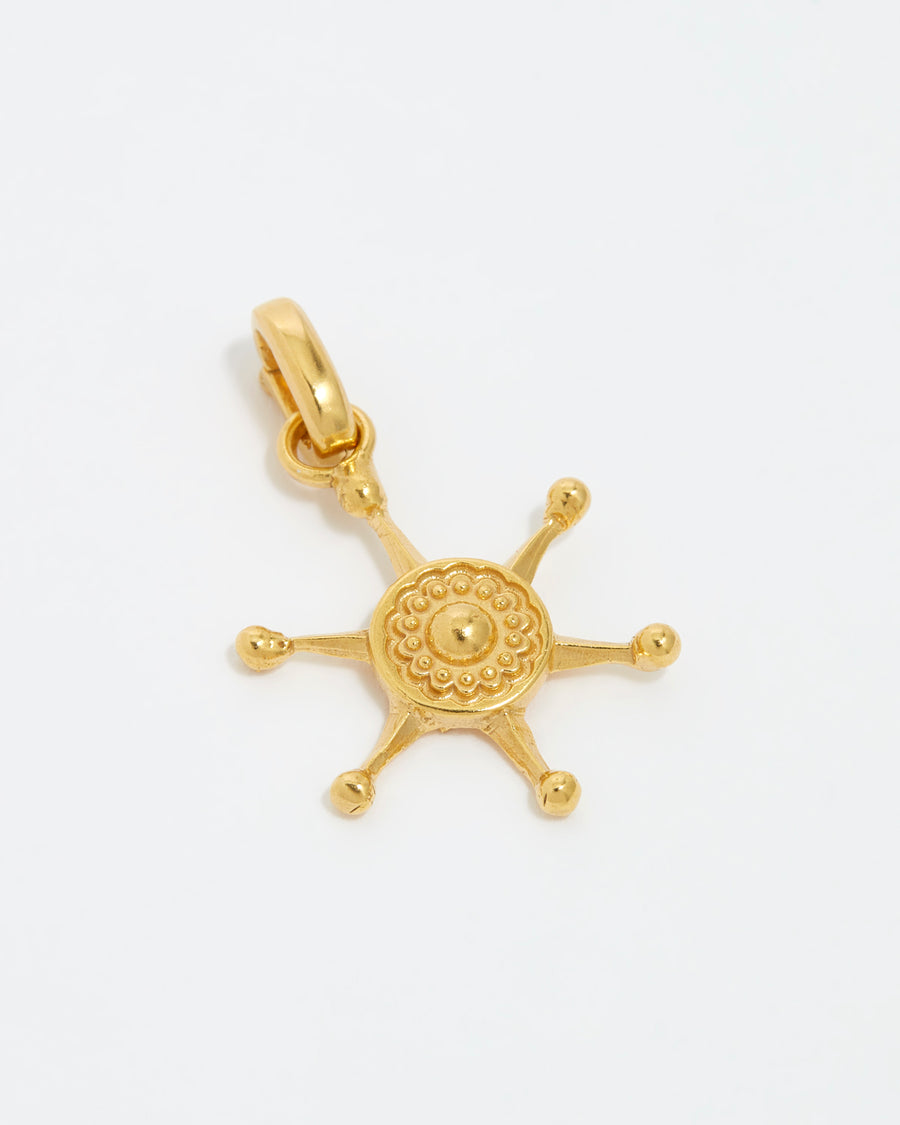 image shot of gold ships wheel charm on a white background