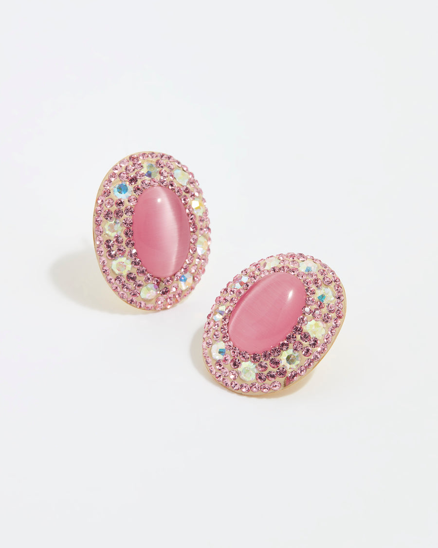 Product shot of Soru Jewellery large pink stud earrings surrounded by crystals on a white background