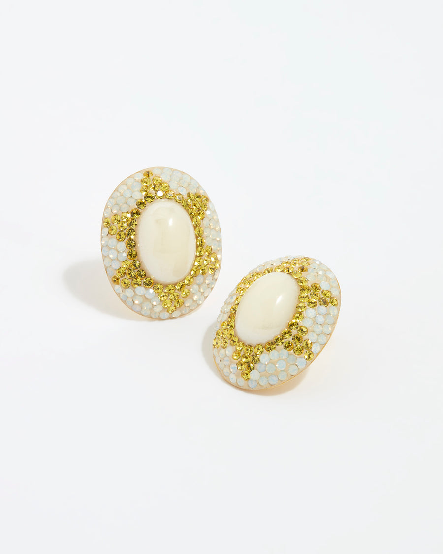 Image shot of large pearl stud earrings surrounded by crystals on a white background