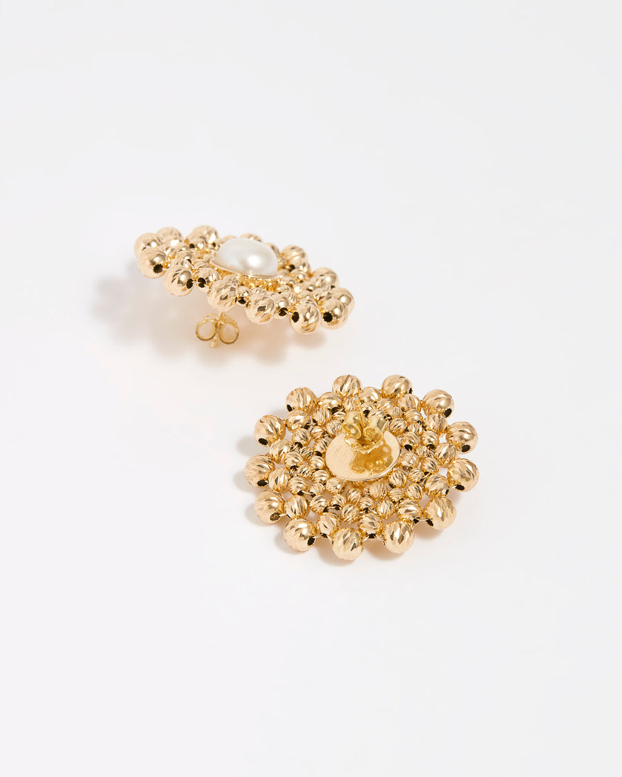 Close up of side and reverse product shot of gold flower shaped beaded earrings featuring a central pearl gemstone on a white background