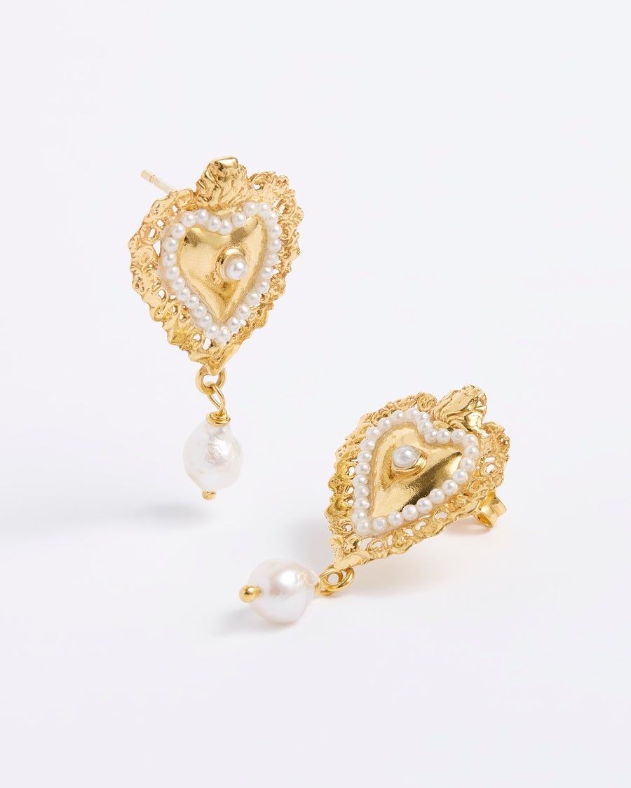 Product shot of mini gold traditional burning heart earrings with pearl detailing.