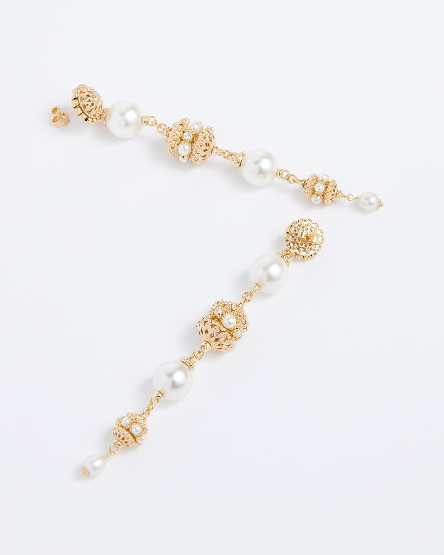 Product shot of statement gold linear earrings with pearl detailing on white background.