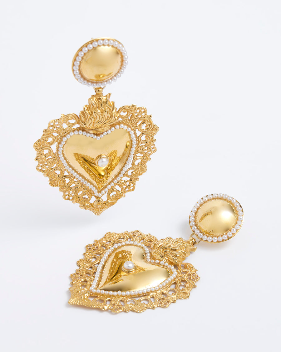 Product shot of gold traditional burning heart statement earrings with pearl detailing.