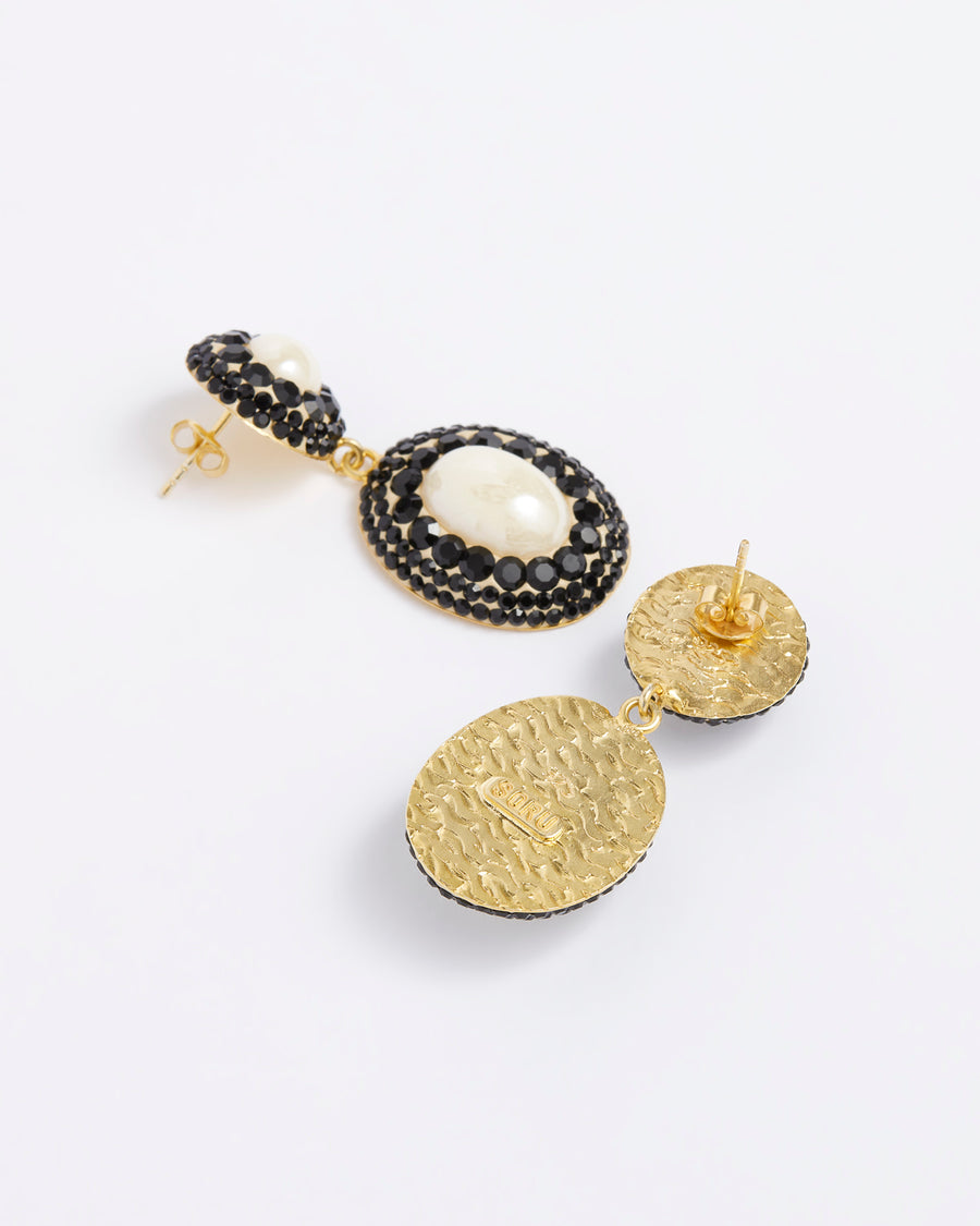 Product shot of statement drop pearl earrings, featuring black crystal detailing, on a white background.