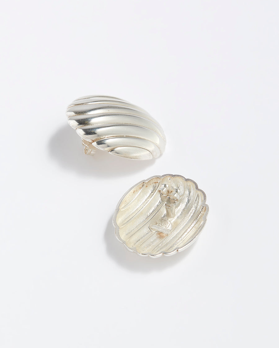 Behind product shot: Silver ribbed statement stud earrings on a white background