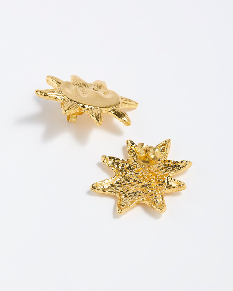 Behind shot of gold celestial moon and sunshine etched stud earrings.
