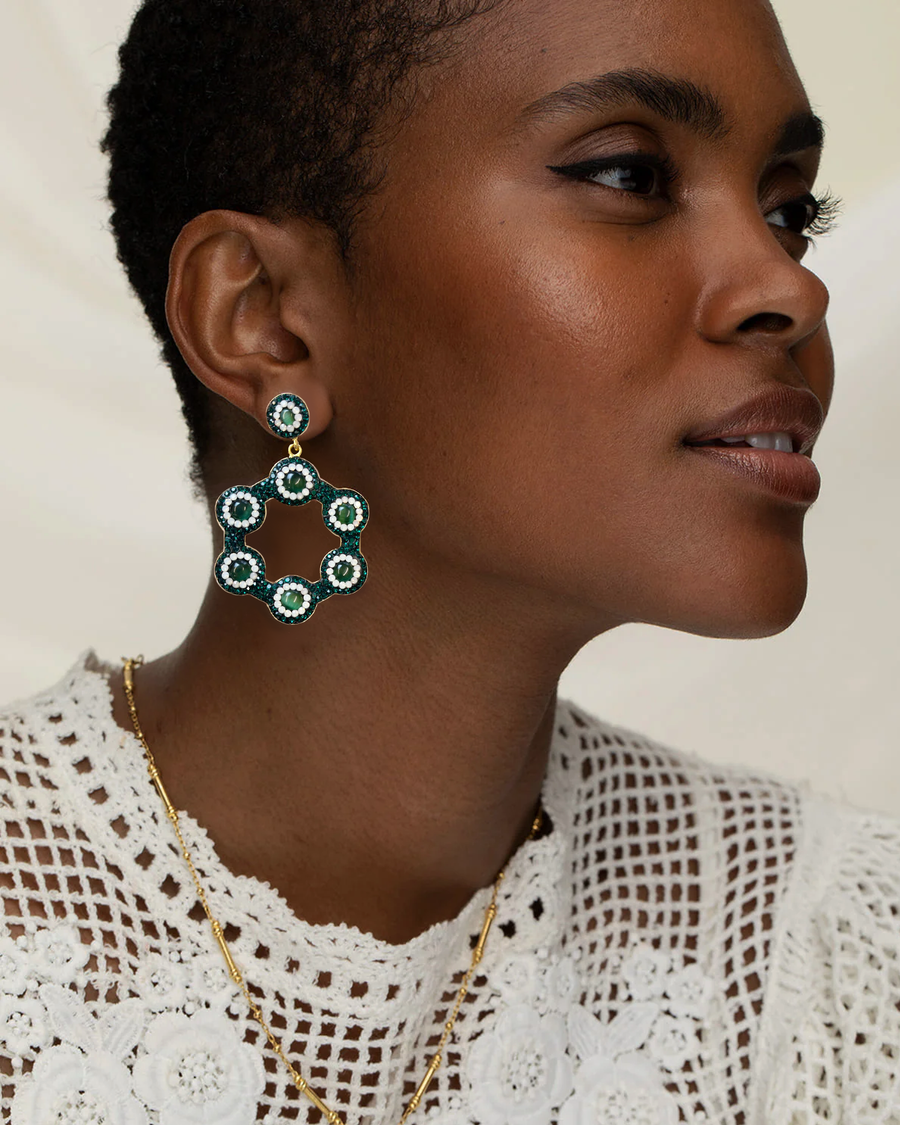 Model wearing Emerald green hoop earrings with vibrant green cat’s eye gemstones, with a lace top