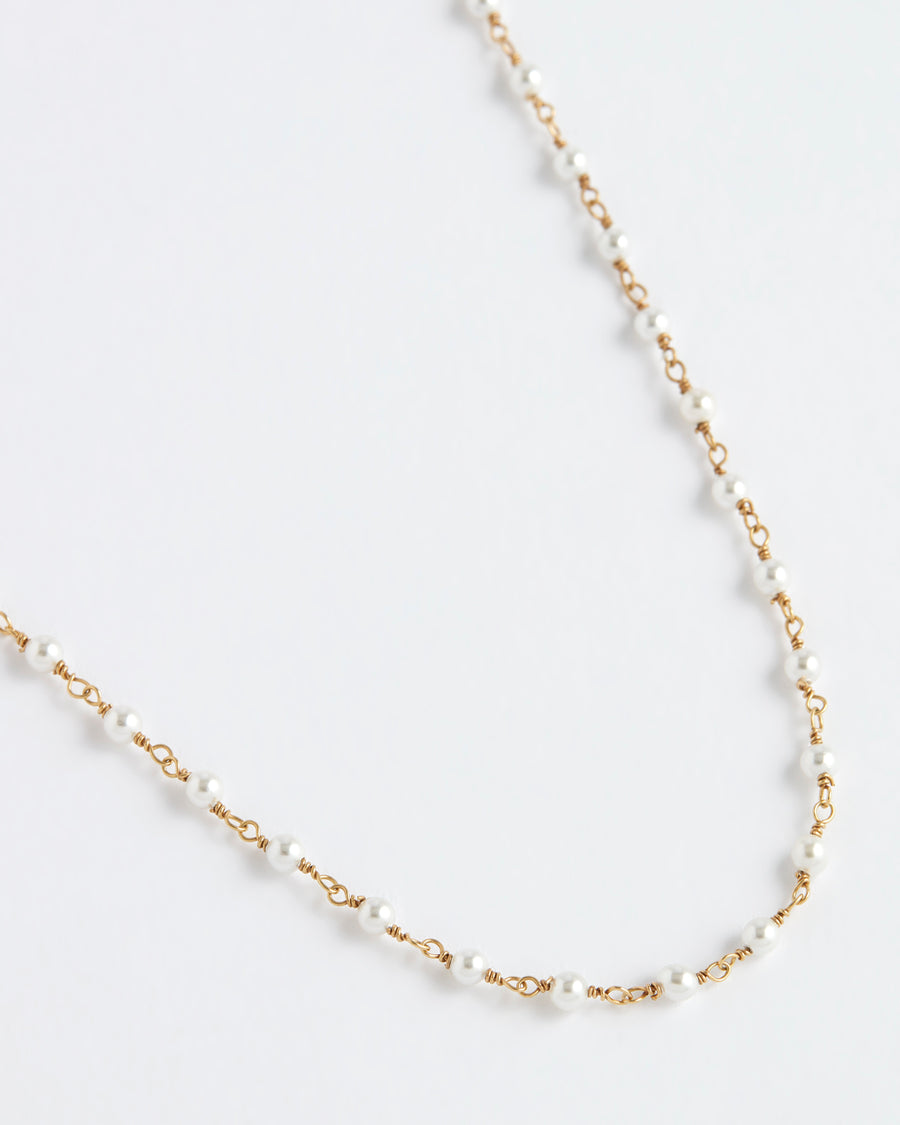 close up product shot of soru jewellery gold and pearl beaded necklace on a white background