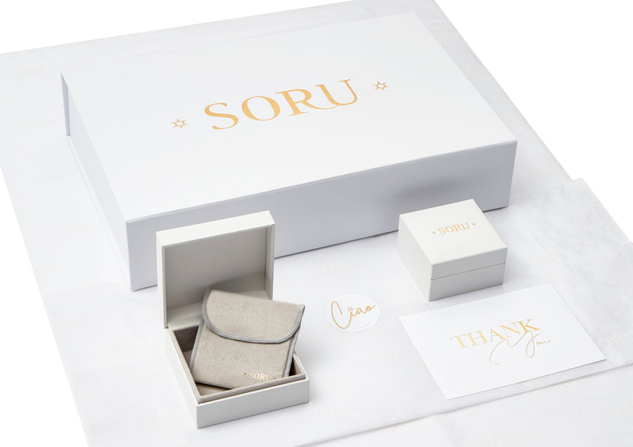 Soru jewellery packaging image on white background showing gift boxes, pouches, branded postcards and tissue paper.
