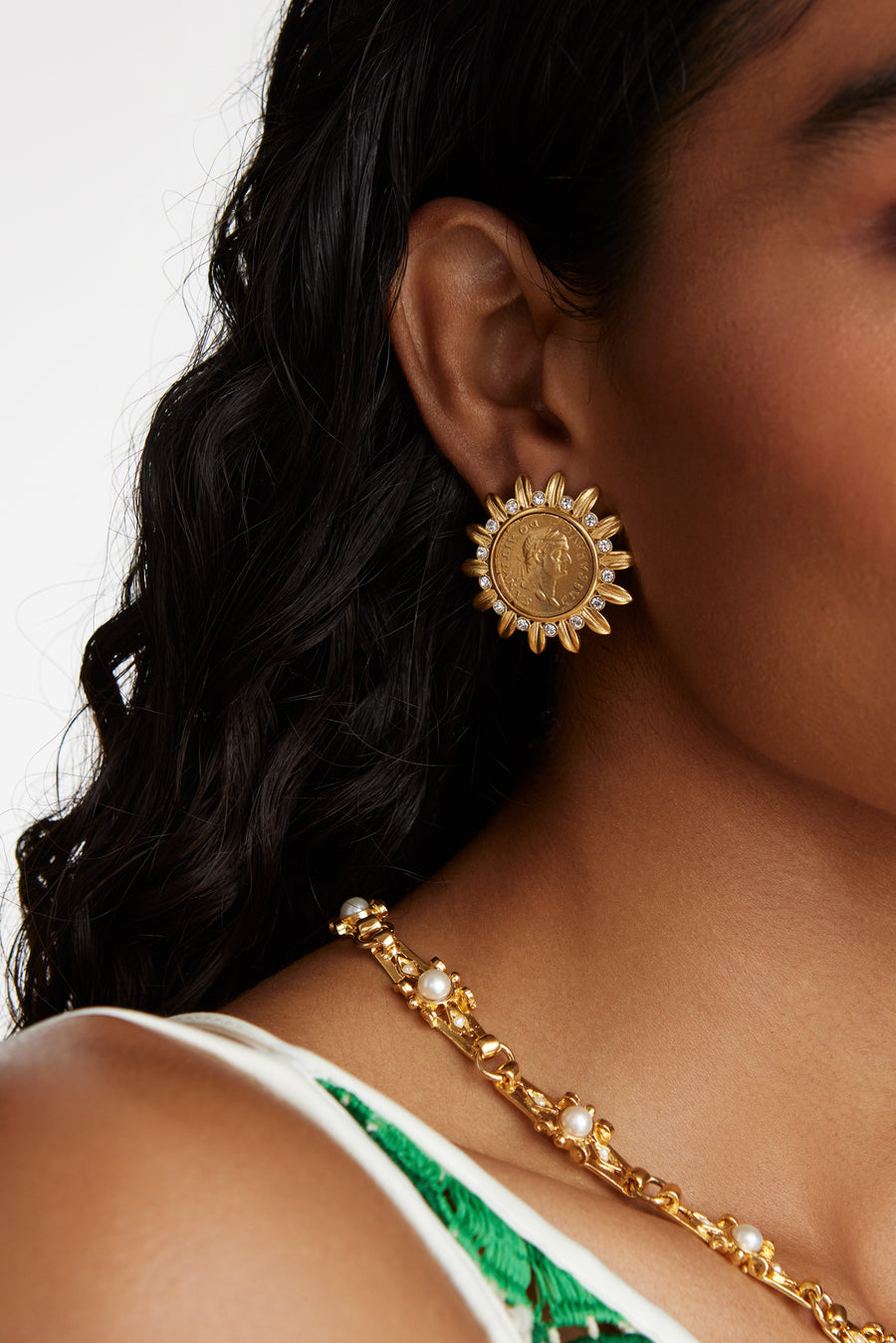 model shot waering the Soru Jewellery crystal embellished coin stud earrings and a gold and crystal necklace