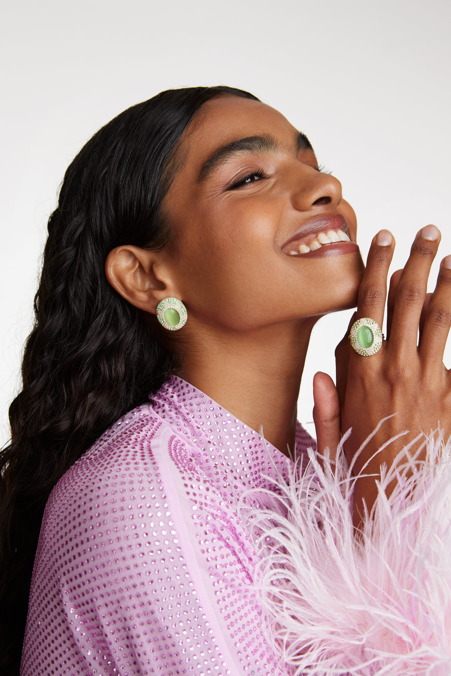 Model shot wearing the Soru jewellery chunky green stone and crystal ring and matching stud earrings while laughing with head tilted back
