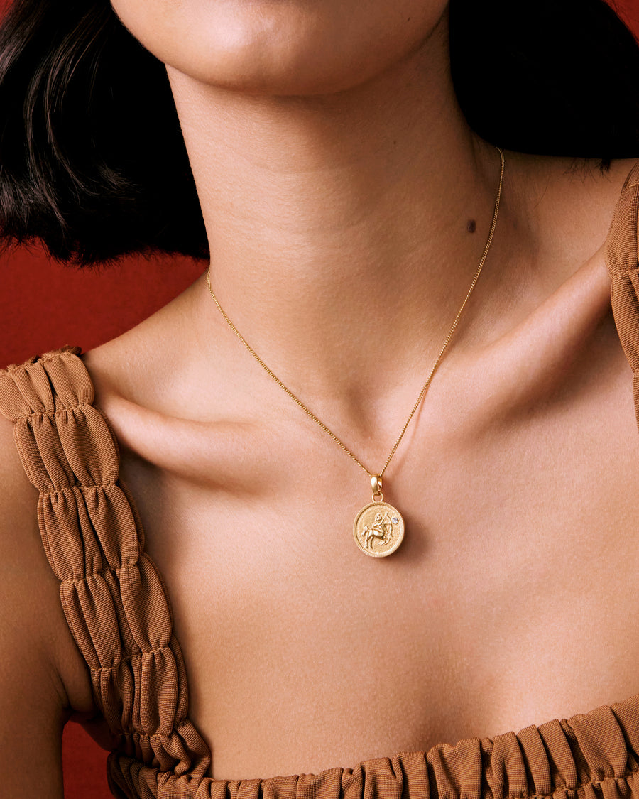 Model shot of the neck wearing a round Aquarius zodiac gold pendant