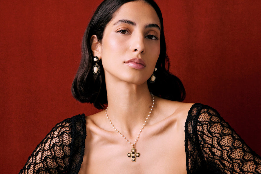 model shot of model wearing pearl cross necklace and white crystal and pearl earrings