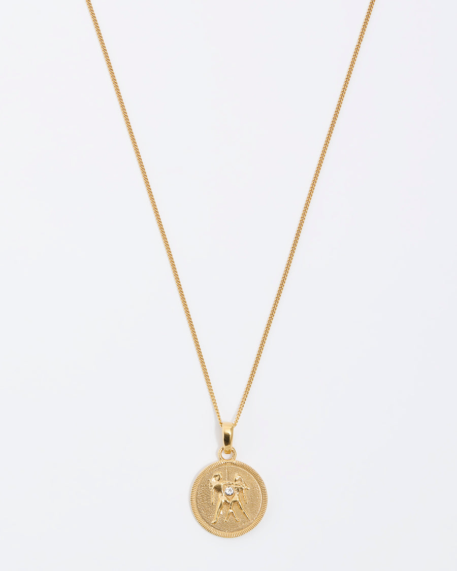 Gemini Zodiac circular gold pendant on a fine gold chain necklace.