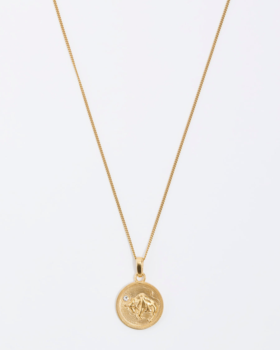 Taurus Zodiac circular gold pendant on a fine gold chain necklace.