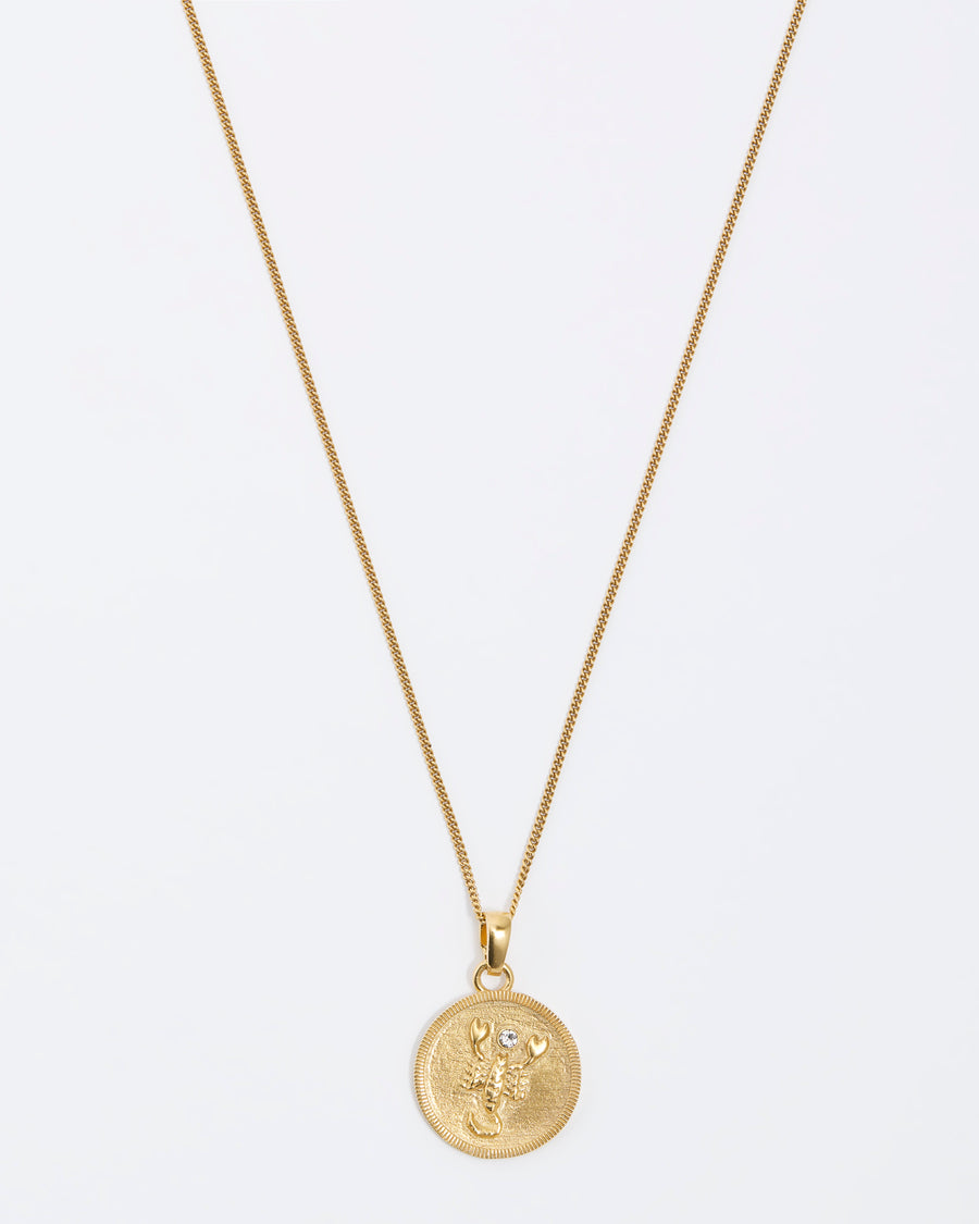 Scorpio Zodiac circular gold pendant on a fine gold chain necklace.